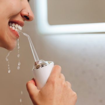 Une femme utilise un hydropulseur dentaire pour son hygiène